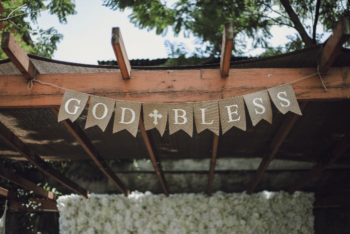 "Hallow" - a photo of a banner above a patio that reads: "God Bless"