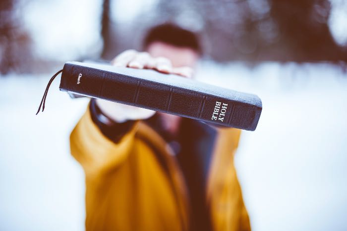 "Righteous as a dirty word" - a photo of a person holding a Bible up to eye-level