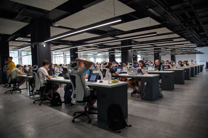 "Clearly work needs to change" - photo of an open office with dozens of workers are at computer desks.