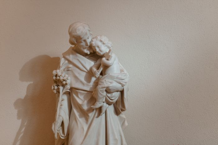 "God’s deal with Joseph" - a photo of a statue of Joseph holding the baby Jesus.
