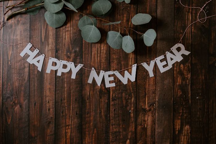"A New Year" - a photo of a wood table with "Happy New Year" on it.