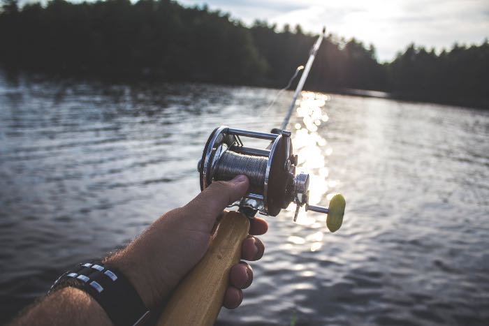 "Dropping Everything" - a photo of a hand holding a fishing rod.