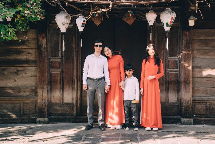 "Beyond Family" - a photo of a family standing in front of a door. A son is dressed like his father and a daughter is dressed like her mother.