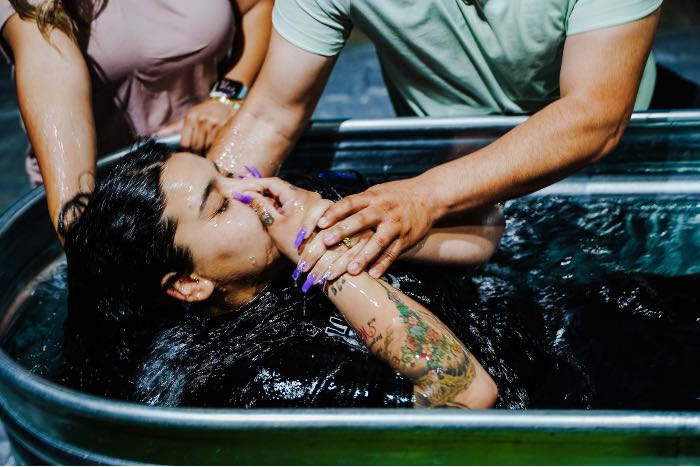 "Turning the Page" - a photo of a person being baptized by immersion.