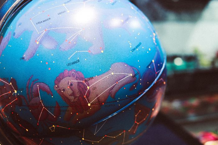 "In Divine Partnership" - a photo of a globe with constellations on it.
