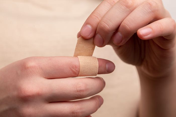 "You have heard it said..." - a photo of a person wrapping a bandaid around their finger.