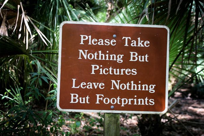 a photo of a sign that reads "Please Take Nothing But Pictures Leave Nothing But Footprints"