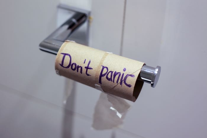 a photo of an empty toilet paper roll, on which someone has written: "Don't Panic".