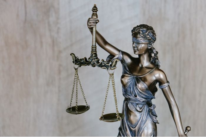 "Liable—dealing with greater responsibility" - a photo of statue of Lady Justice holding scales.