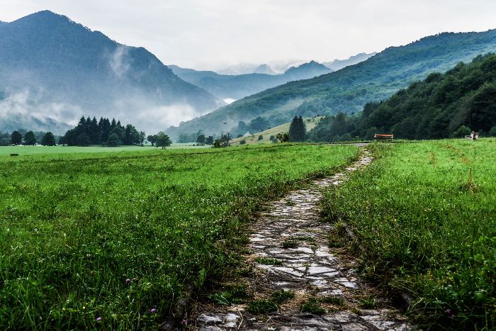 a photo of a stone path, mountains in the distance