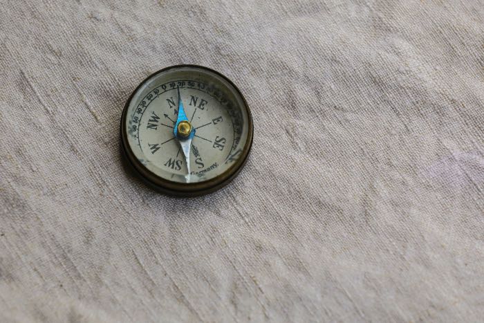 a photo of a compass on a canvas surface
