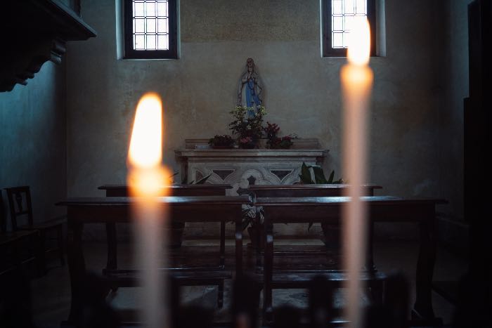 a photo of an altar in a chapel, candles in the foreground are out of focus.