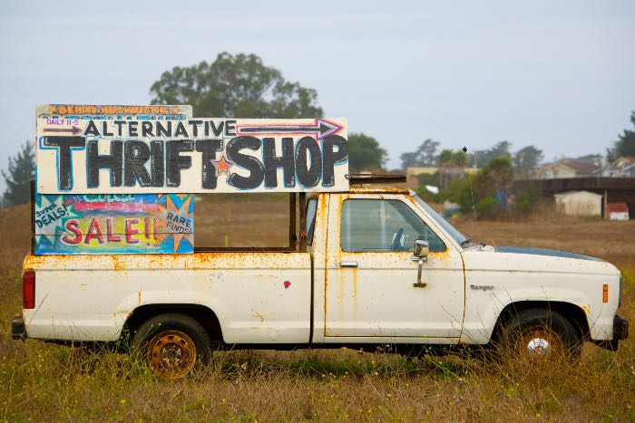 a photo of a truck with a sign on the back reading: "Alternative Thrift Shop"