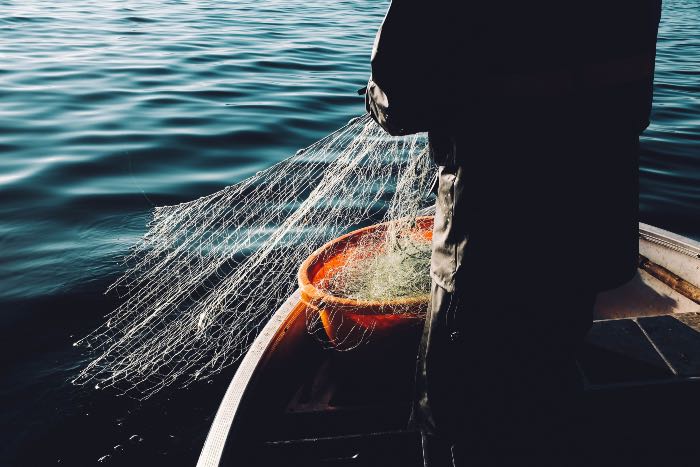 a photo of a person casting a fishing net into the water