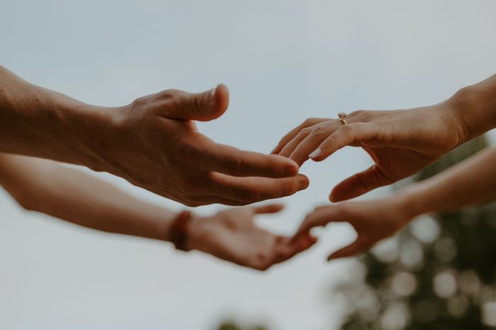 a photo of two hands reaching out to two other hands in support.
