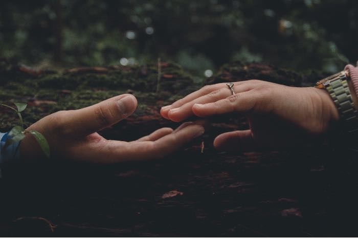 a photo, close up, of two hands reaching out, touching