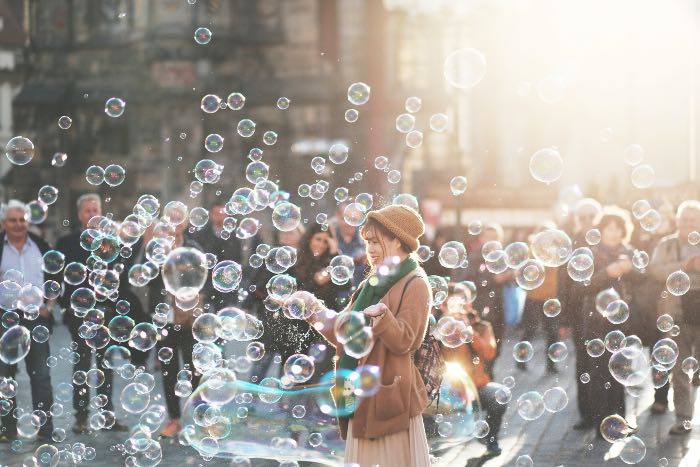 a photo of a person blowing many bubbles in the city
