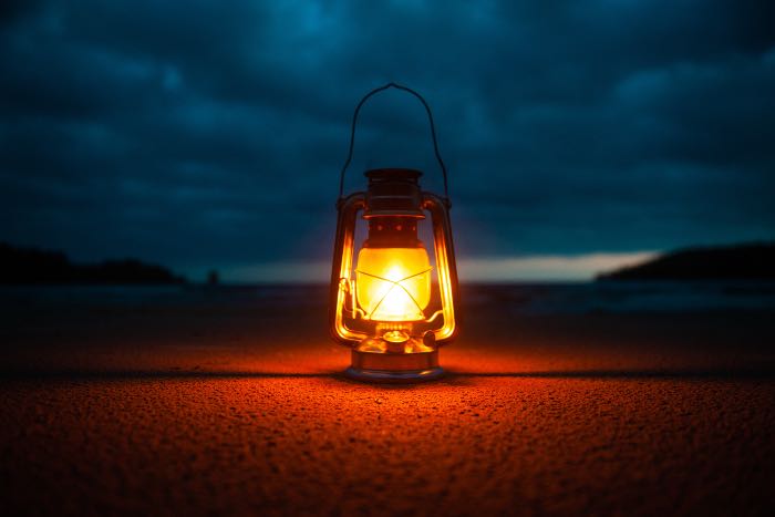 a photo of a lantern on a desert floor at night.