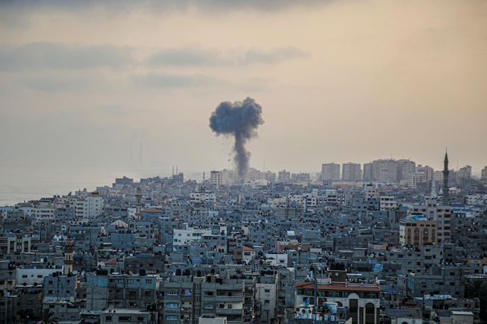 a smoke cloud rising up from a city in Gaza
