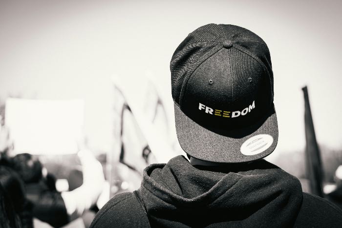 a photo of the back of a head, their hat reads "freedom".