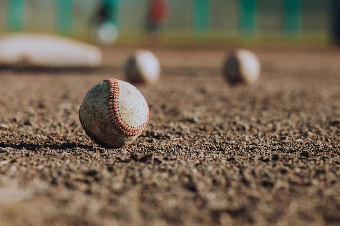 a photo of baseballs on the dirt of a diamond