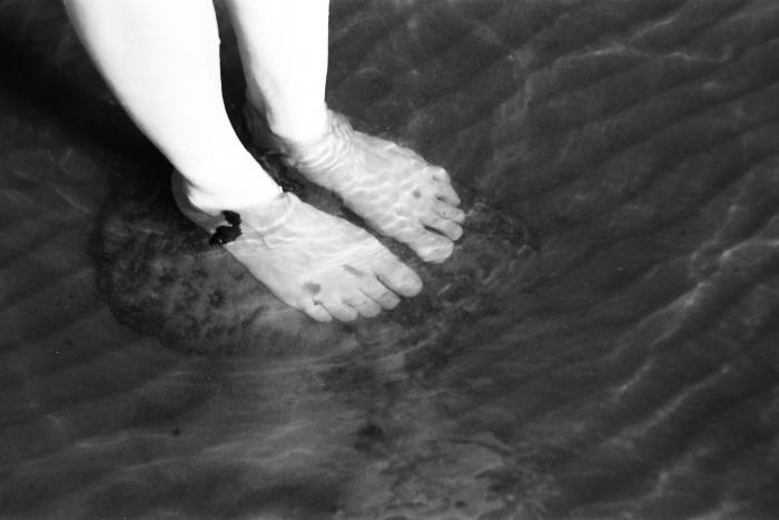 a photo of bare feet in water