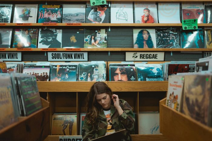 a photo of a person sitting in the floor of a record store.