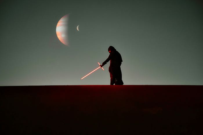 a photo showing a figure with a red lightsaber