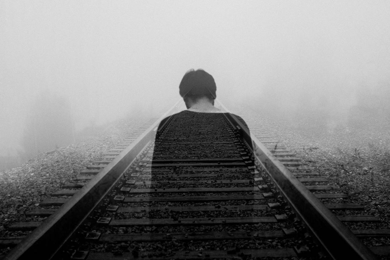 a photo of a person on railroad tracks—an effect making him appear somewhat transparent