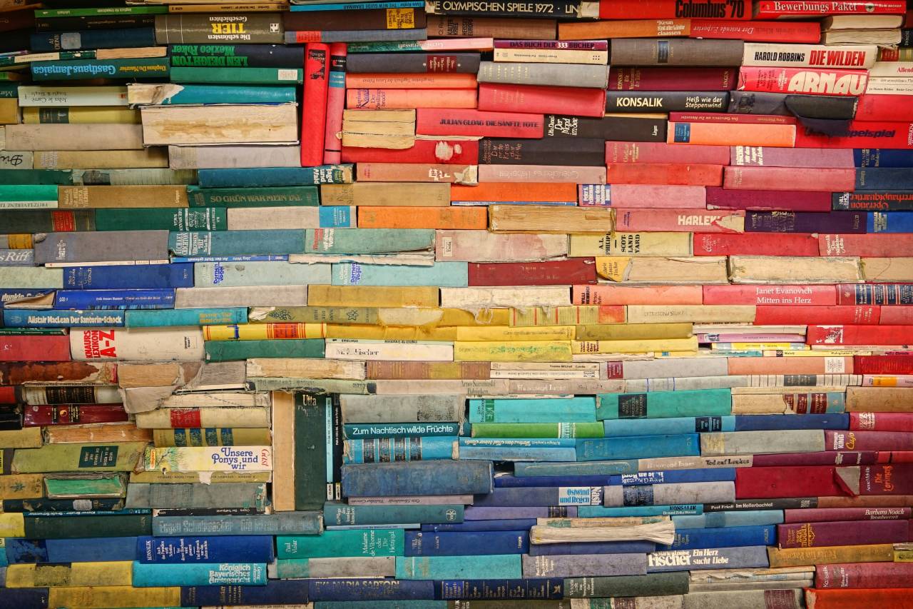 a photo of book spines, arranged by color and stacked on top of each other