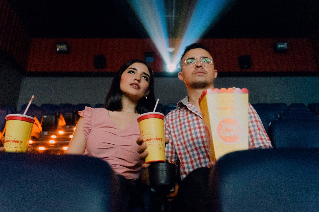 a photo of a couple watching a movie in a theater