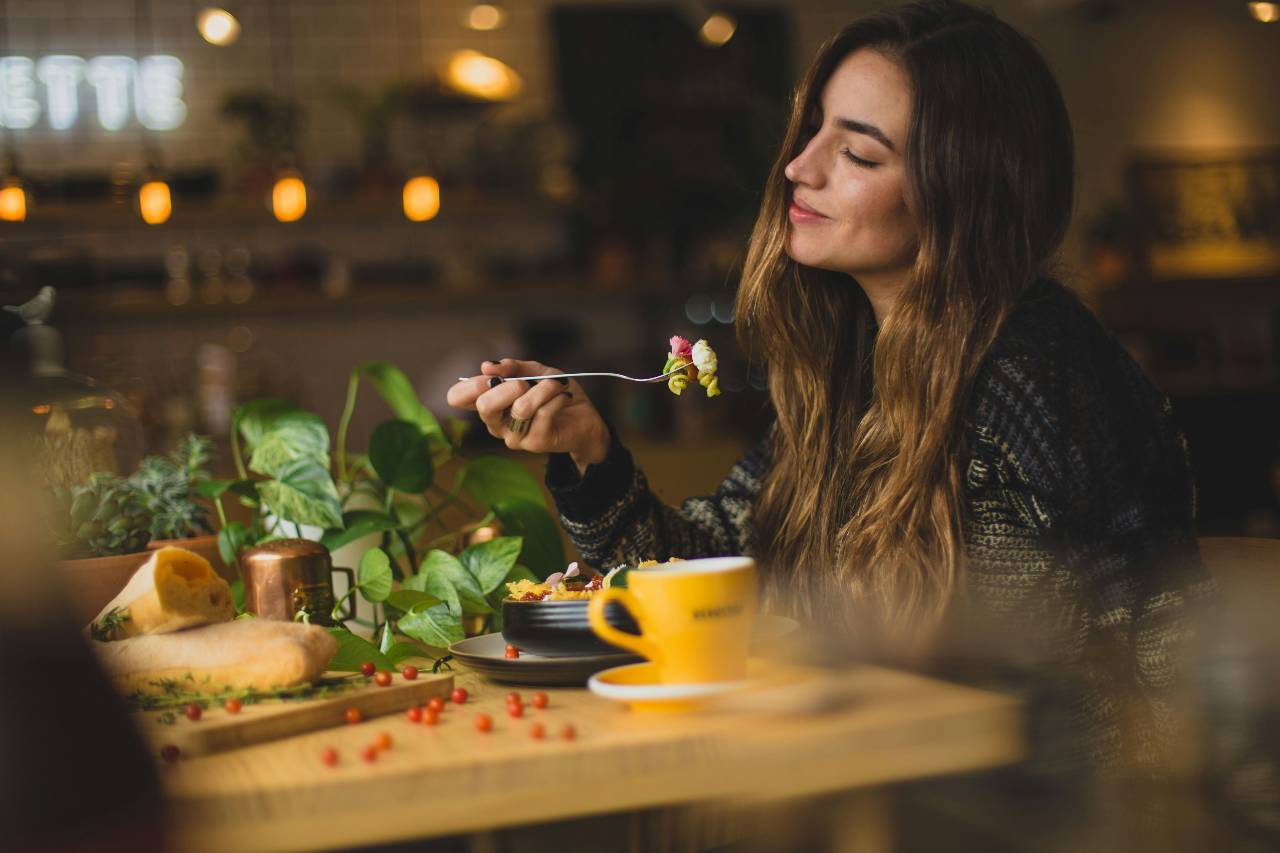 a photo of a person eating, enjoying her food