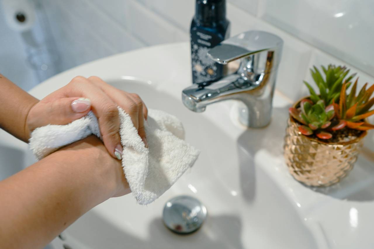 a photo of a person washing, drying their hands