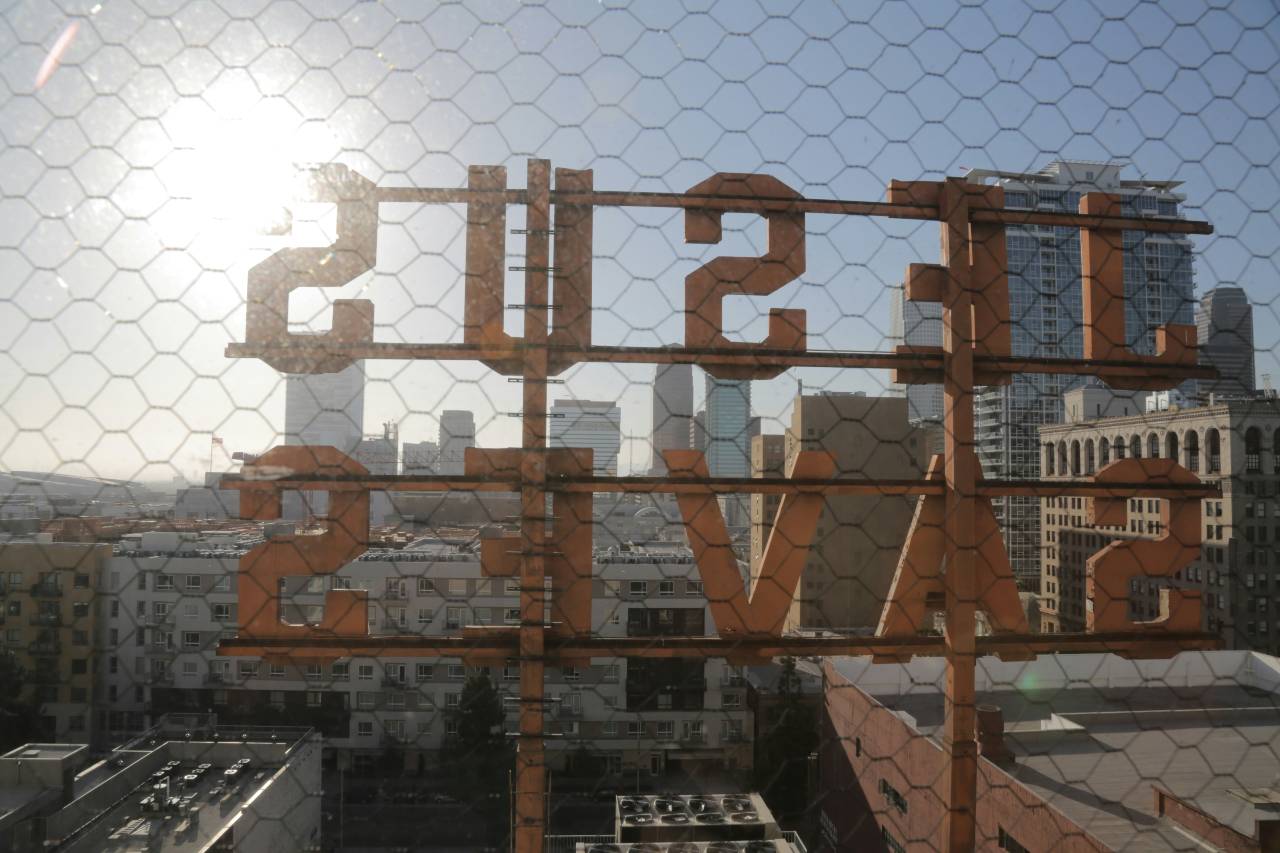 a photo of a sign on the roof of building from behind. It reads "Jesus Saves".