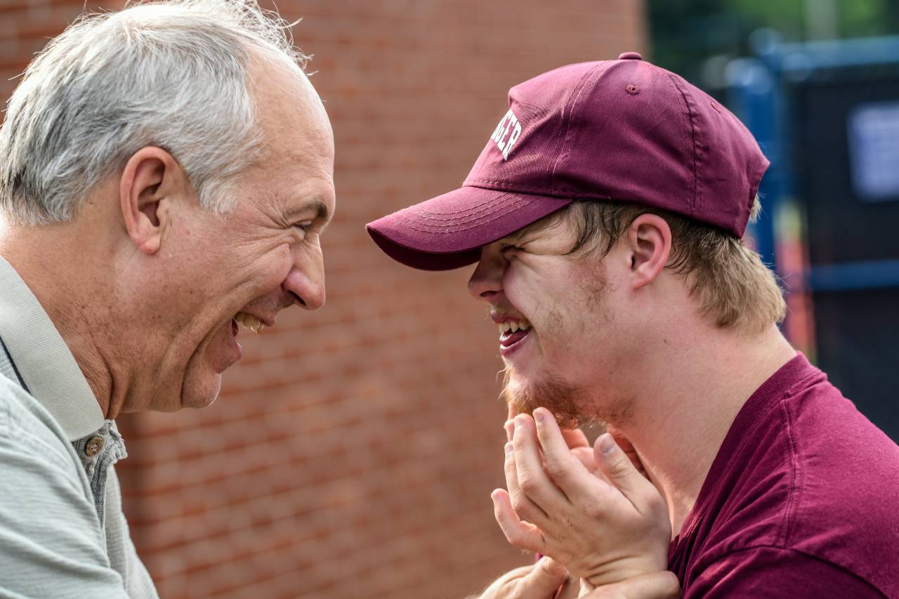 A photo of two people smiling at each other