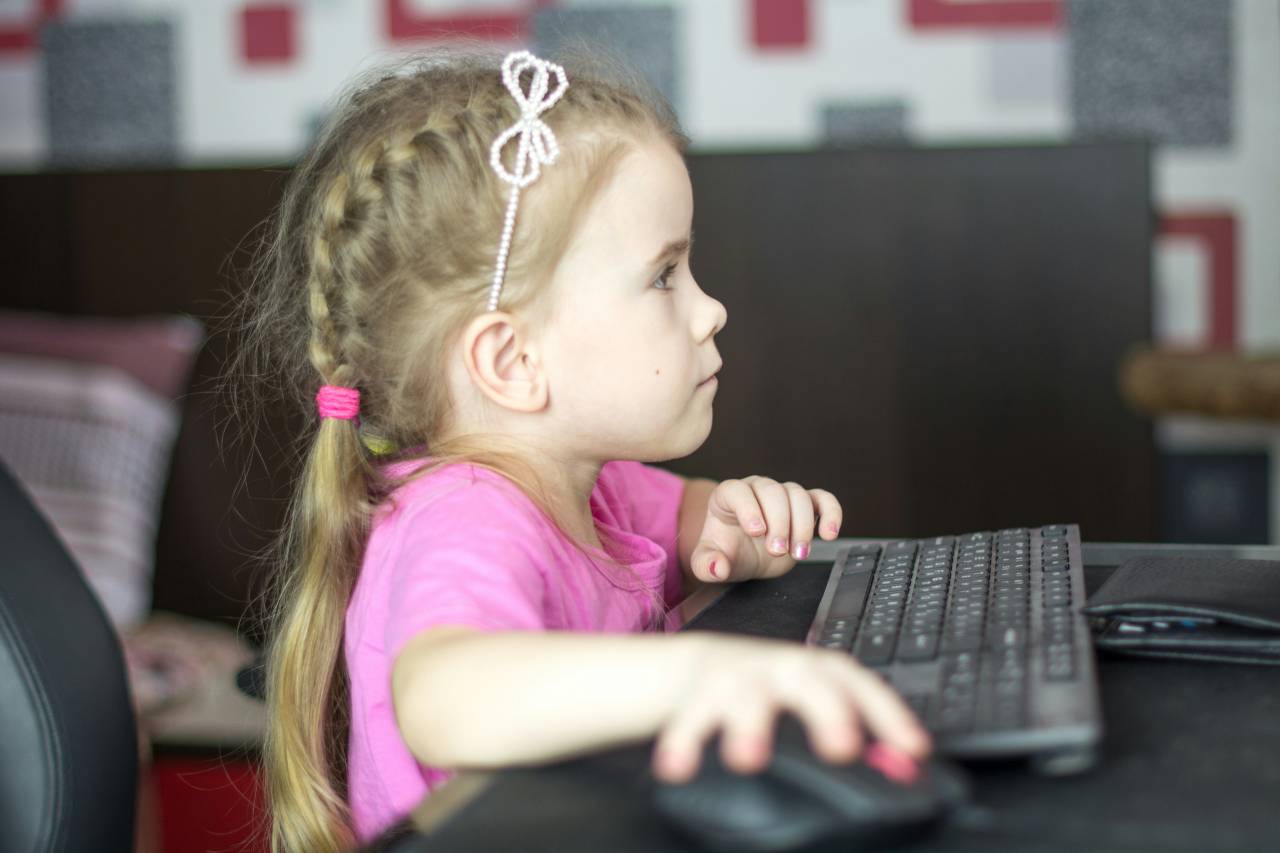 a photo of a young girl clicking a mouse