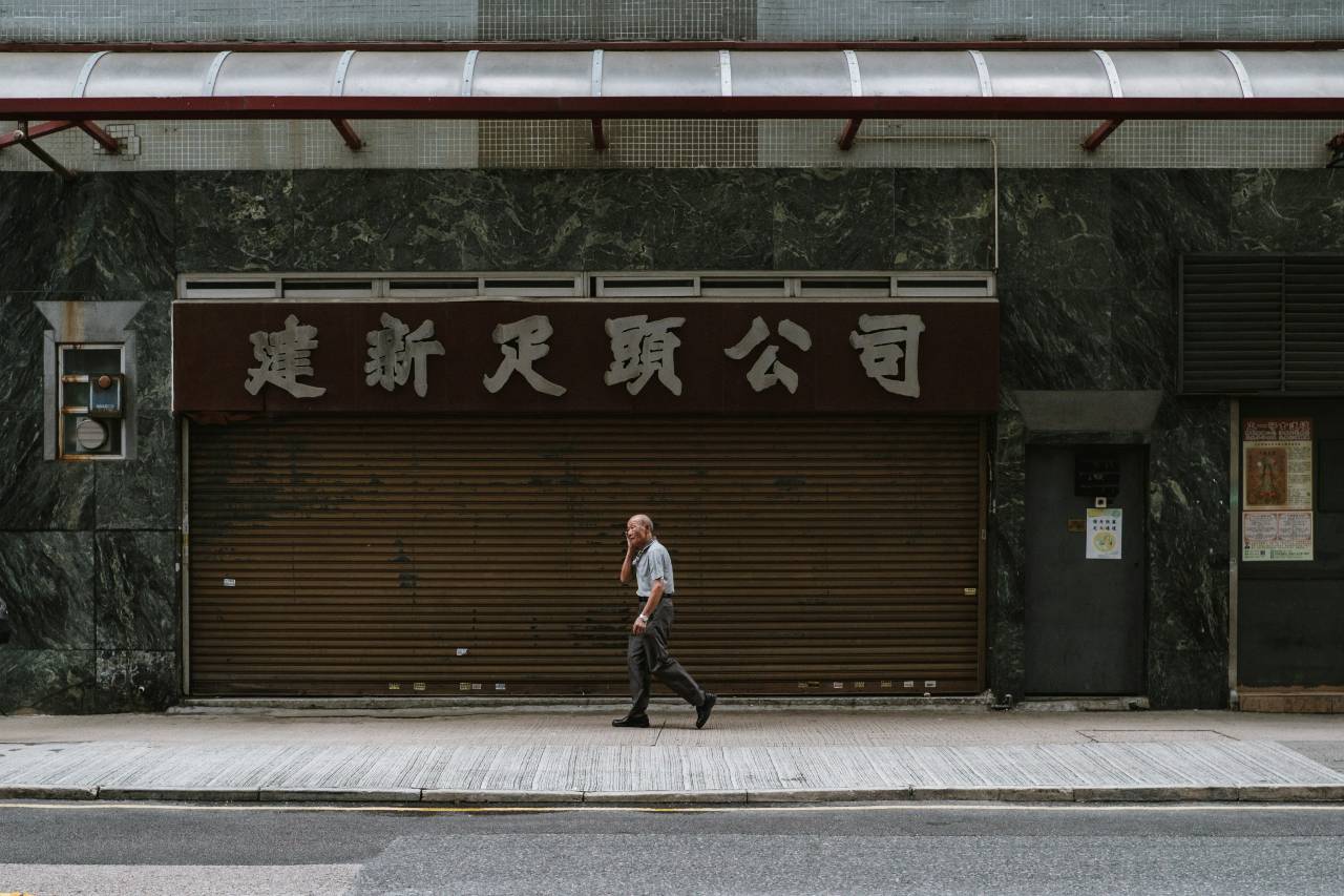 a photo of a person walking on the sidewalk across the street