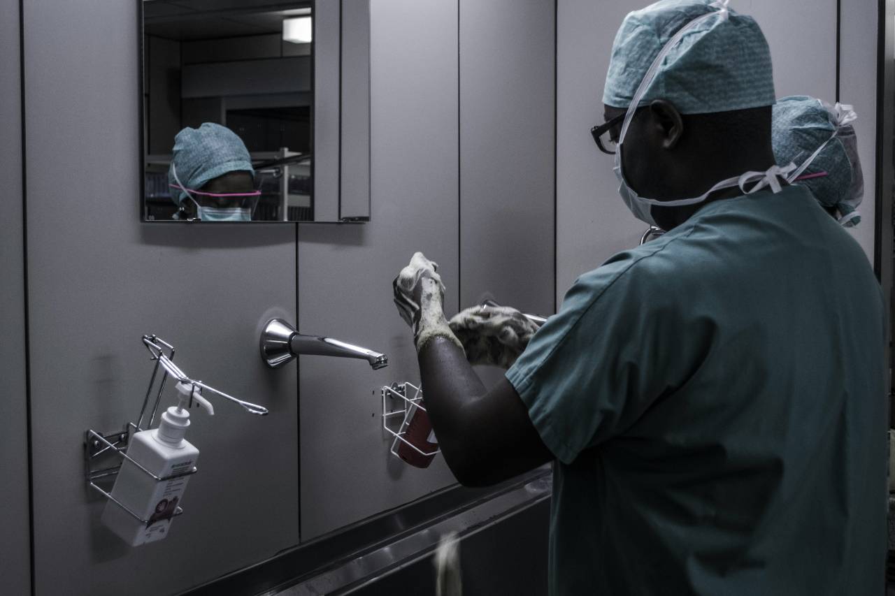 a photo of doctors washing up to enter a surgical room