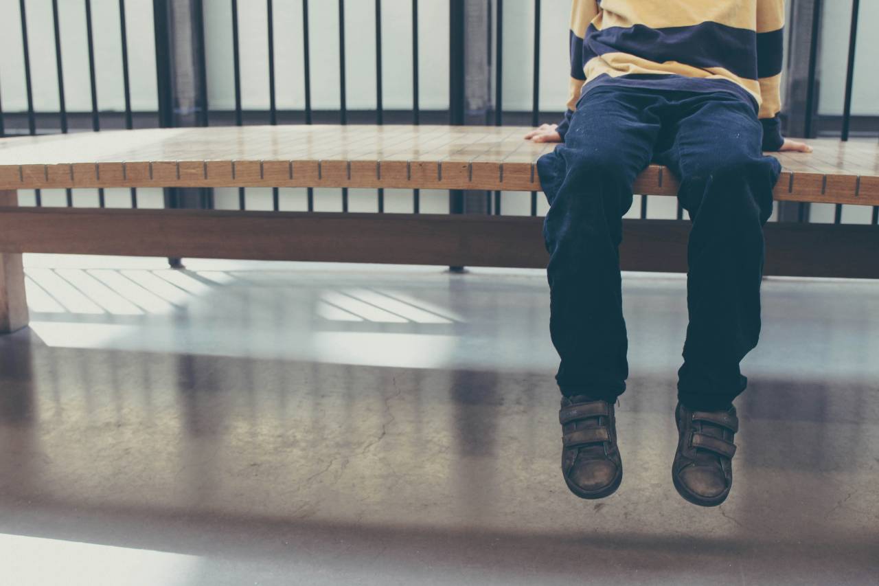 a photo of a child sitting on a bench