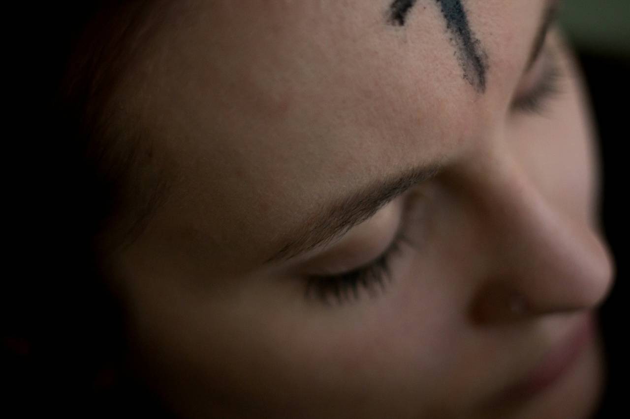 a woman's face, an ash cross on her forehead