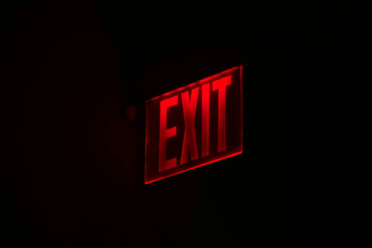 an exit sign glowing red in the dark