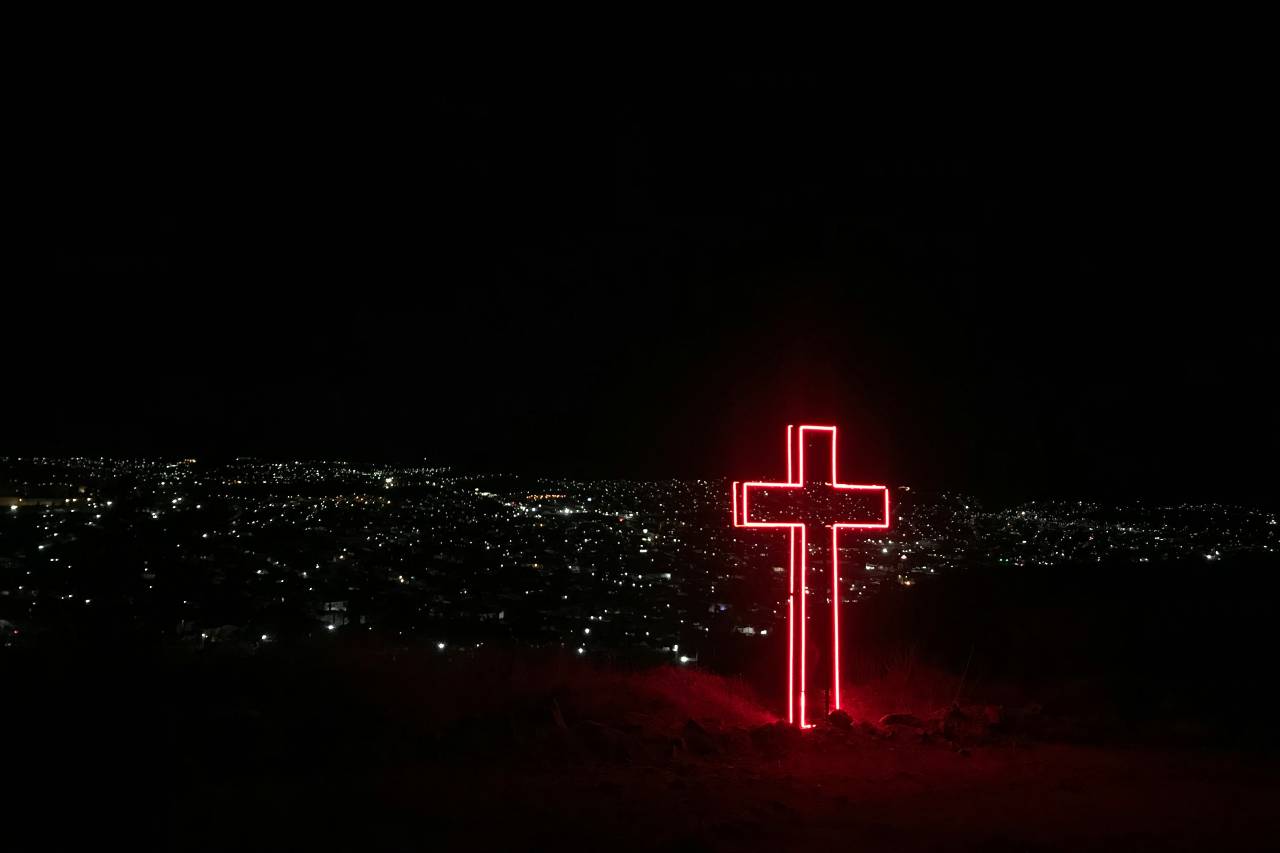 a cross, at night, lit with red lights