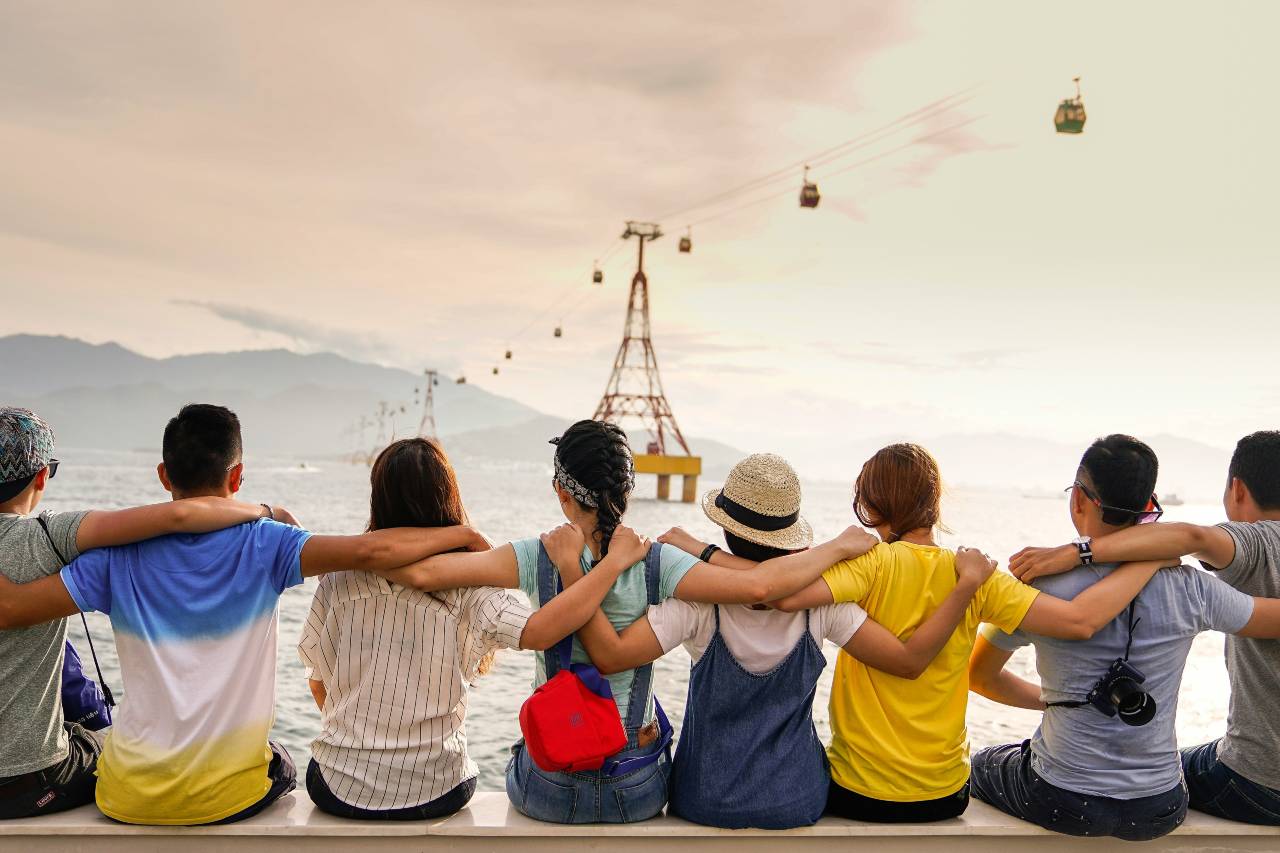 friends sitting together, arms over each others shoulders