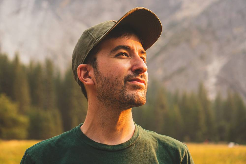 a man wearing a hat, looking to the side